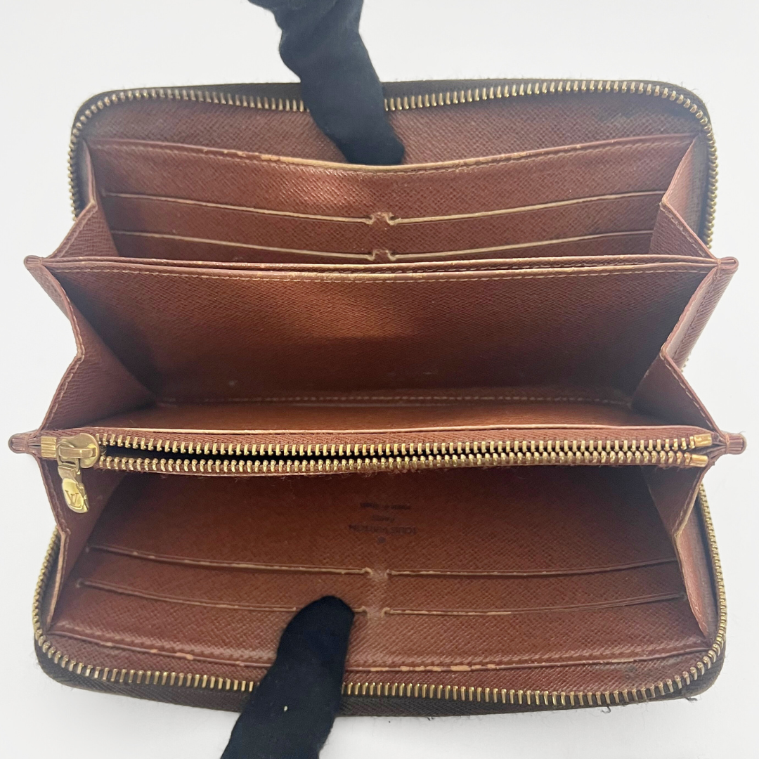 Brown leather wallet with gold zipper on a white background