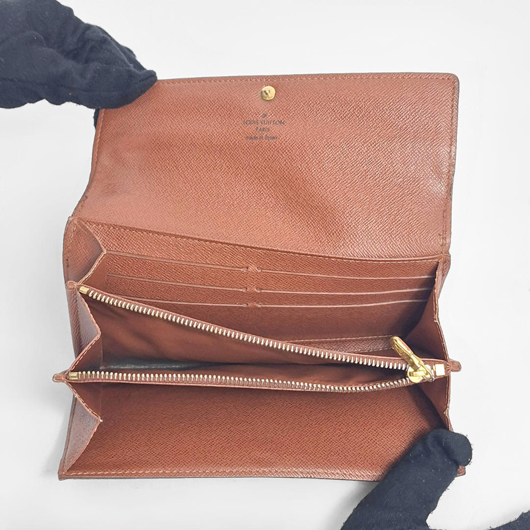 Brown leather wallet with gold zipper on a white background