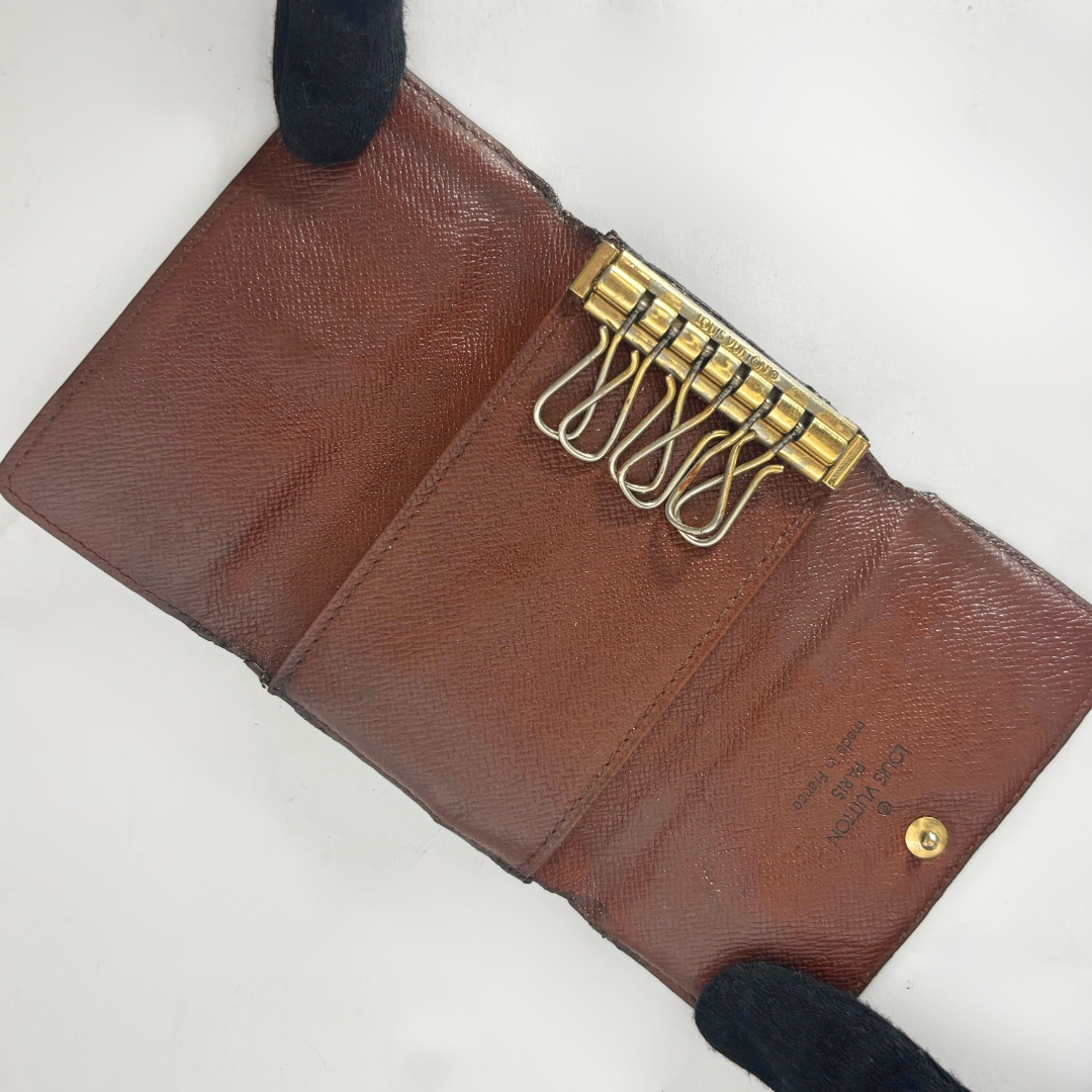 Brown leather wallet with gold keychain on a white background