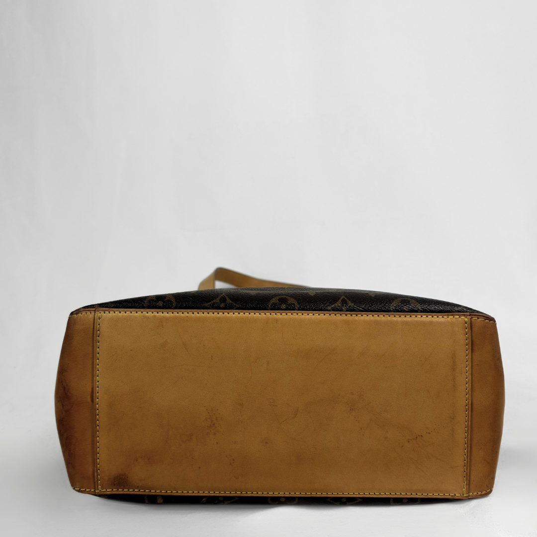 A Louis Vuitton shoulder bag shown from the back, featuring a tan leather back panel and dark brown monogram canvas sides, photographed against a neutral light gray background.