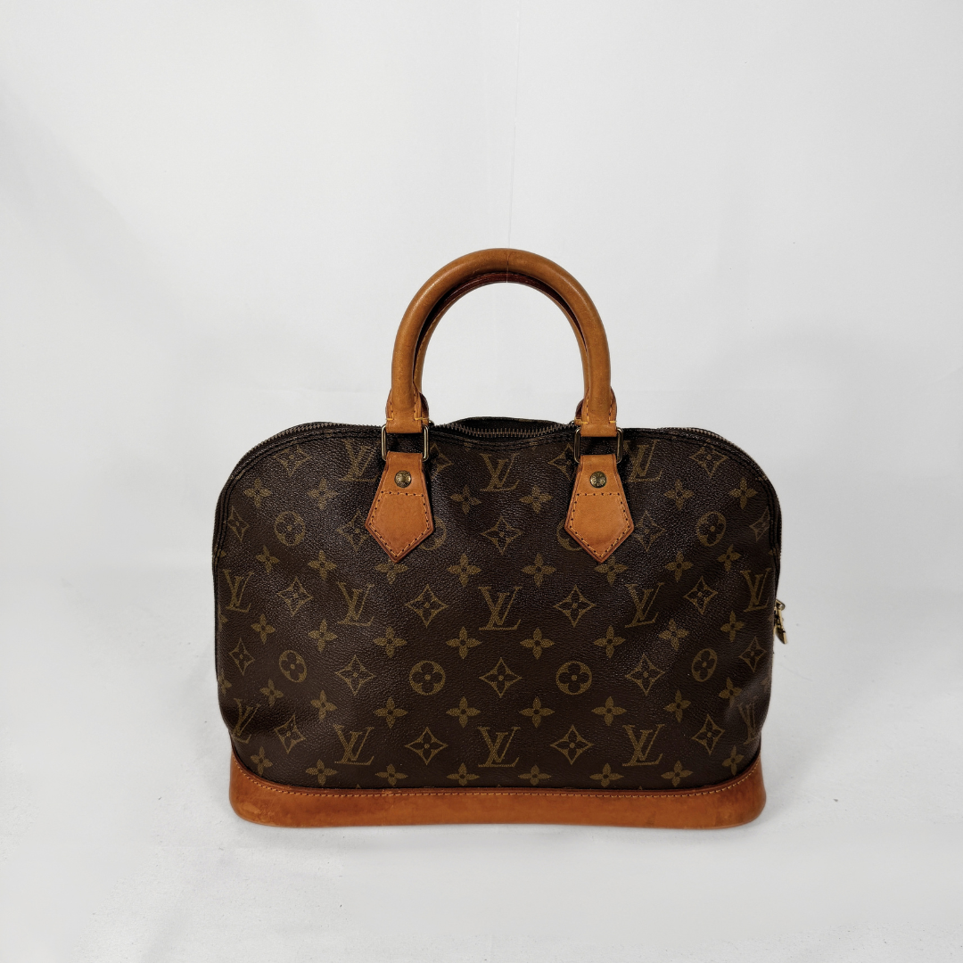 Louis Vuitton monogram canvas handbag with tan leather handles and trim, photographed against a plain light background.