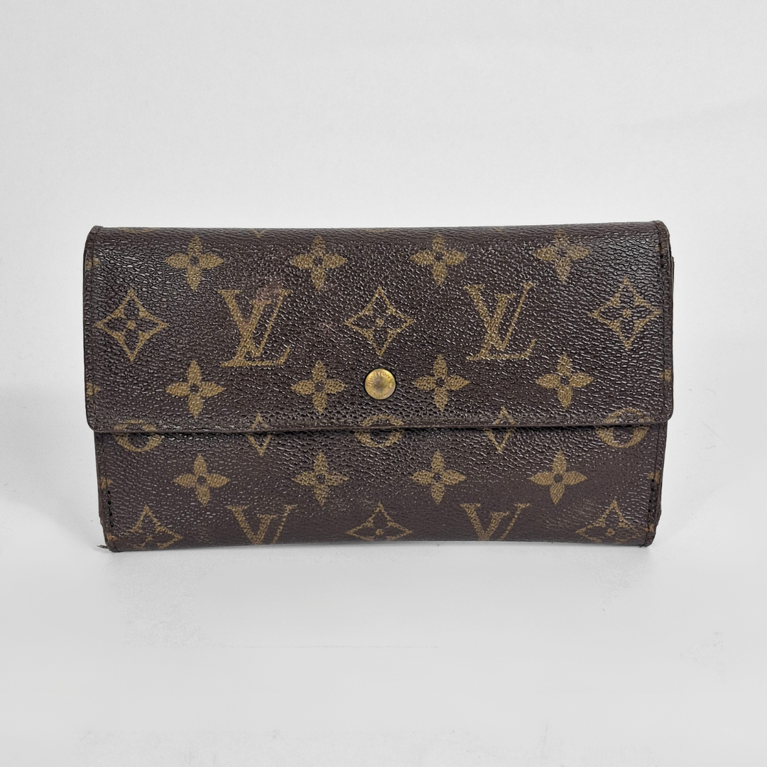 Louis Vuitton wallet with monogram pattern on a light gray background