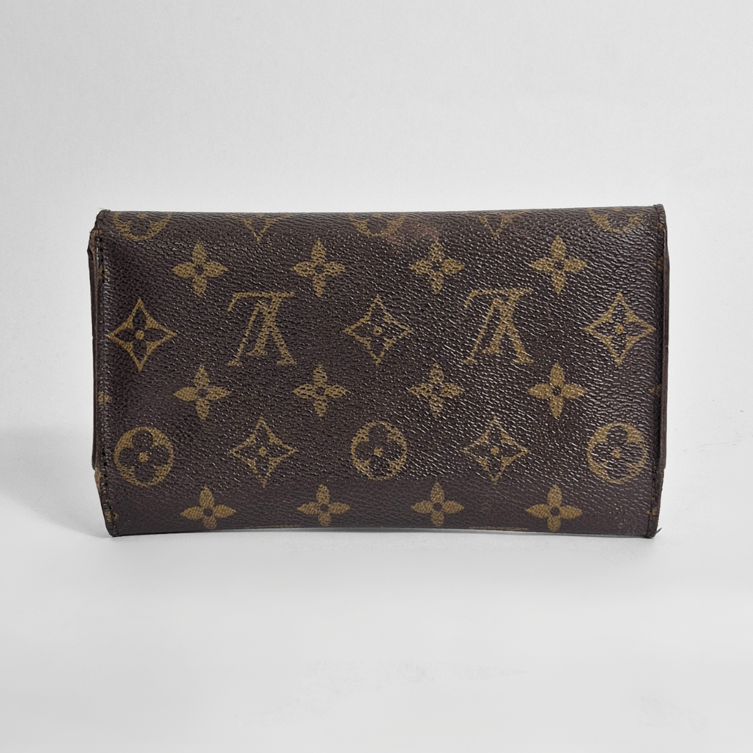 Brown wallet with monogram pattern on a light gray background