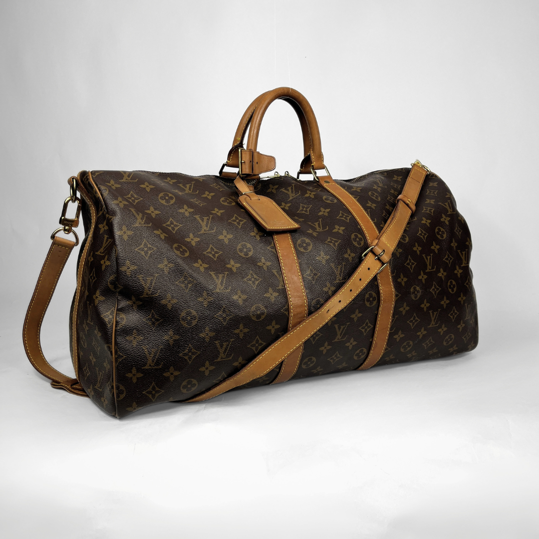 A Louis Vuitton monogram canvas duffel bag with tan leather handles, trim, and shoulder strap, photographed on a light gray studio background.