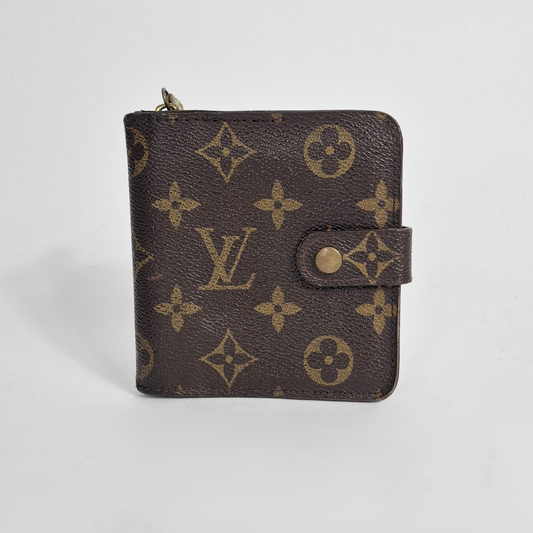 Louis Vuitton wallet with monogram pattern on a light gray background