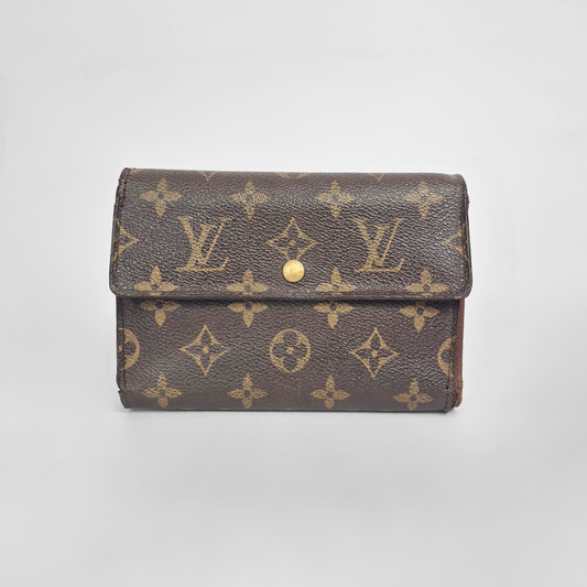 Louis Vuitton wallet with monogram pattern on a light gray background