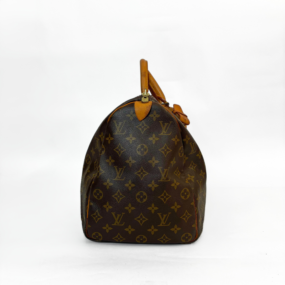 Brown handbag with monogram pattern on a white background
