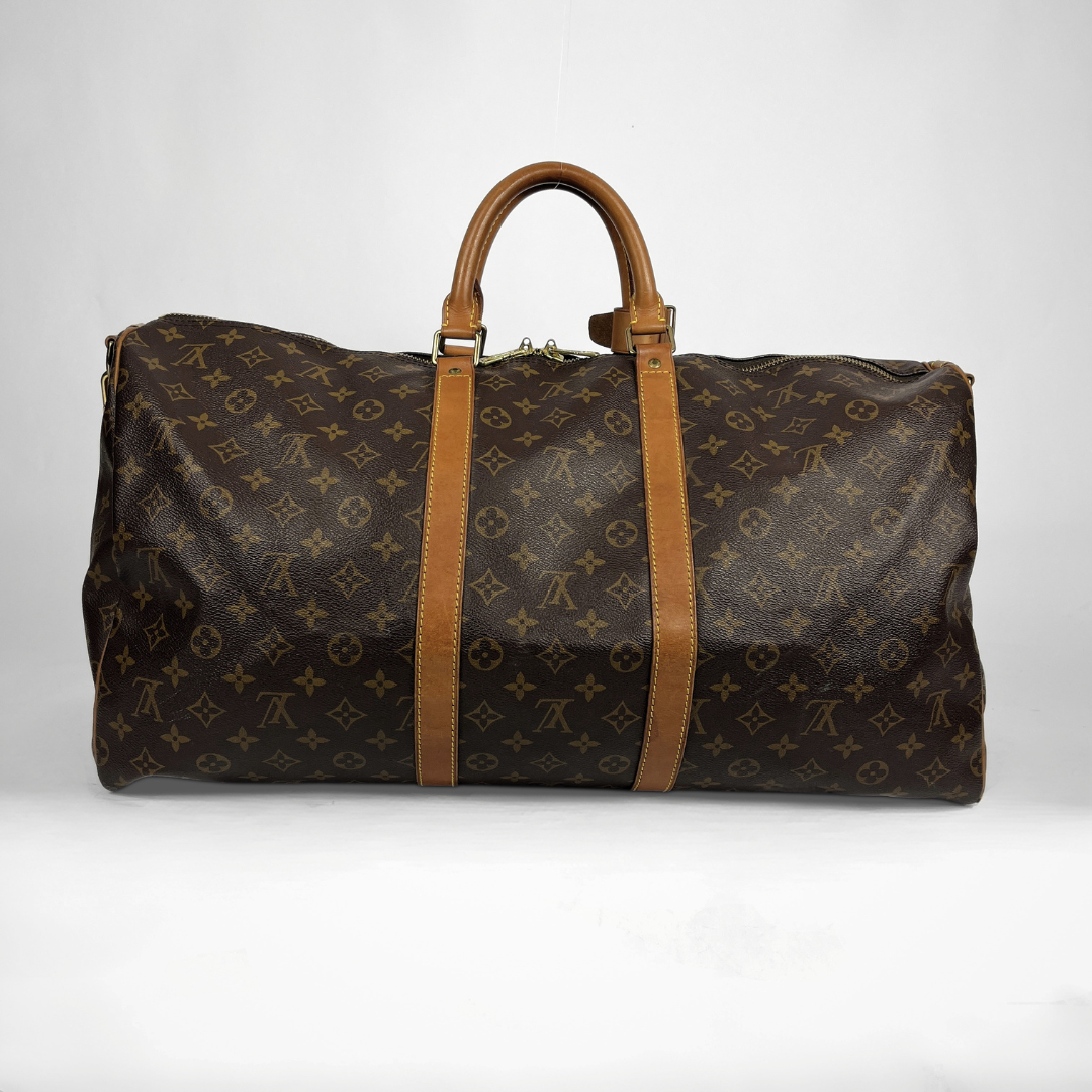 A Louis Vuitton monogram canvas duffel bag with tan leather handles and side straps, photographed against a plain light gray background.