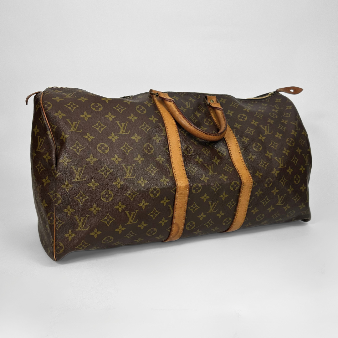 Brown travel bag with tan handles and trim on a white background