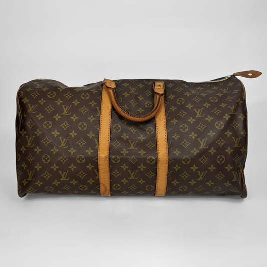 Brown travel bag with tan leather straps on a white background