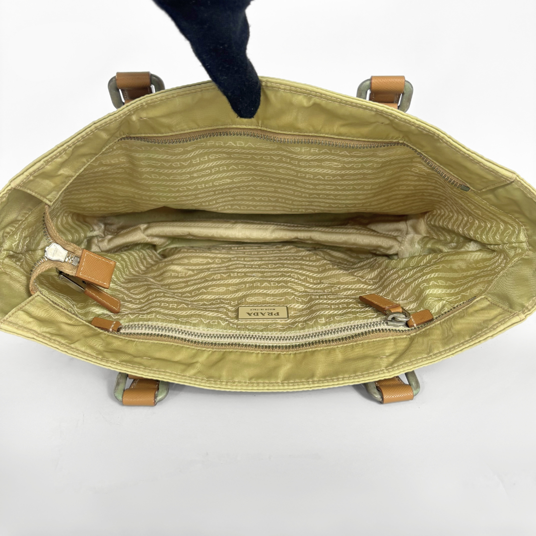 Prada yellow nylon tote bag with tan leather handles and triangle logo.