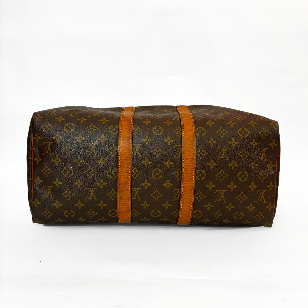 Brown monogram patterned bag with orange straps on a white background