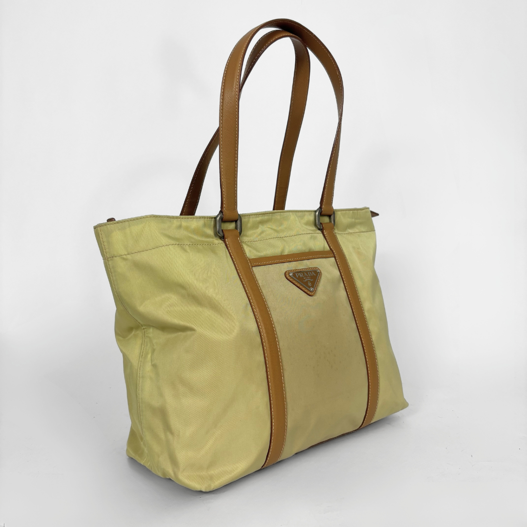Prada yellow nylon tote bag with tan leather handles and triangle logo.