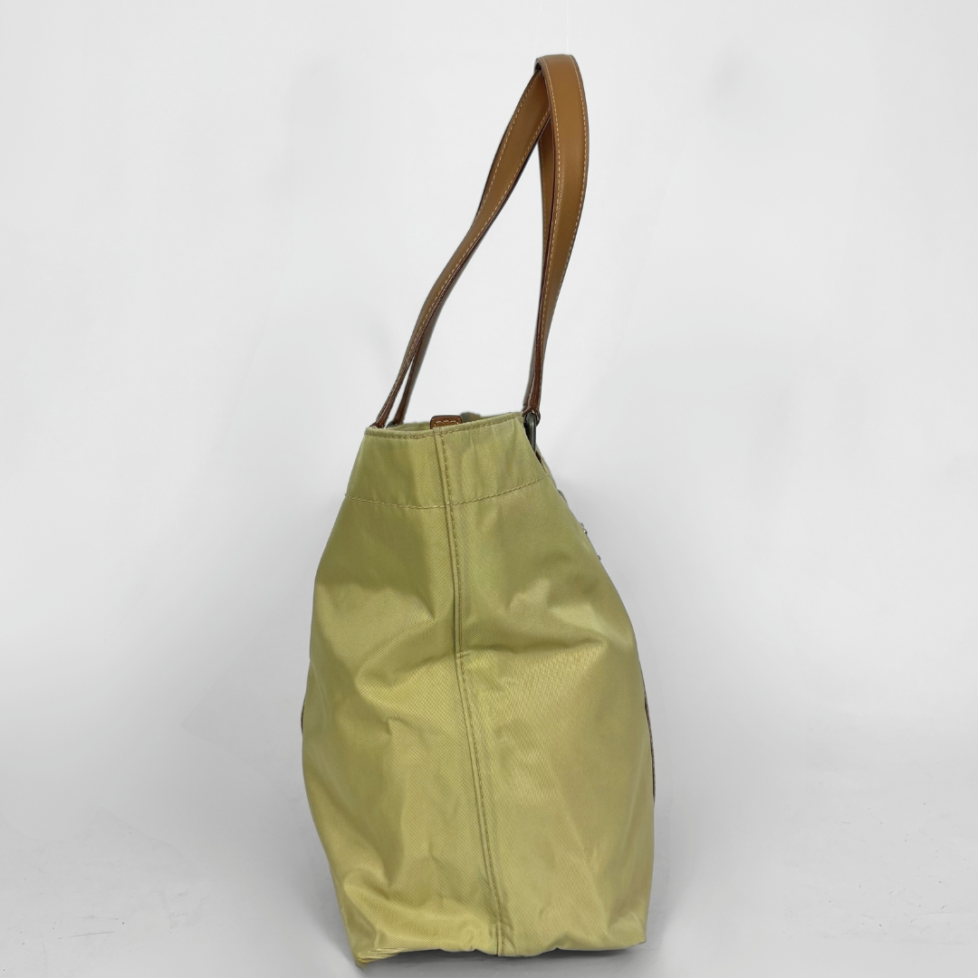 Prada yellow nylon tote bag with tan leather handles and triangle logo.