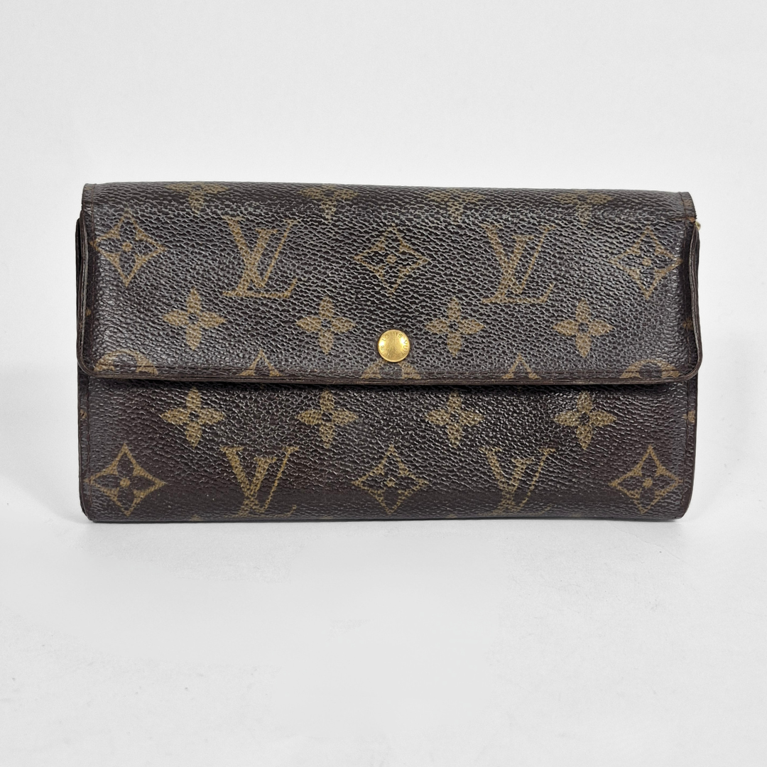 Louis Vuitton wallet with monogram pattern on a light gray background