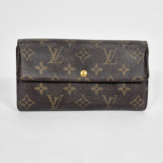 Louis Vuitton wallet with monogram pattern on a light gray background
