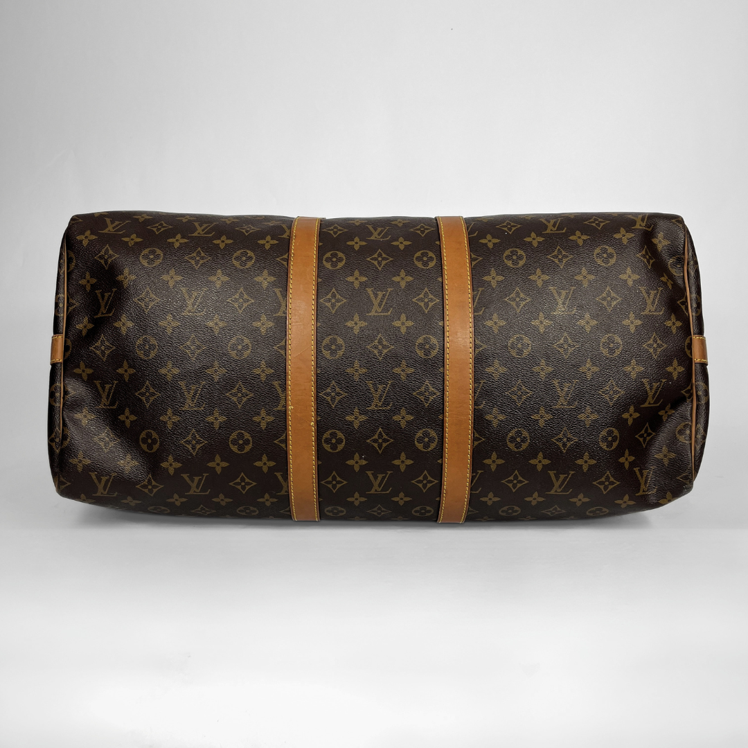 A Louis Vuitton monogram canvas duffel bag with tan leather trim and straps, photographed against a neutral light gray background.