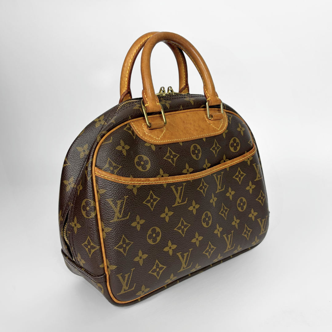 Louis Vuitton monogram canvas handbag with tan leather handles and trim, photographed on a light gray studio background.