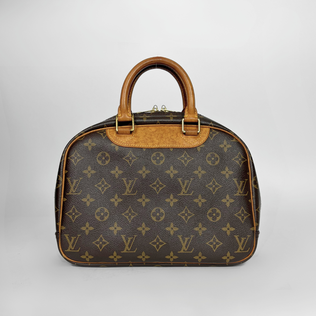 Louis Vuitton monogram canvas handbag with brown leather handles and trim, photographed against a light gray studio background.