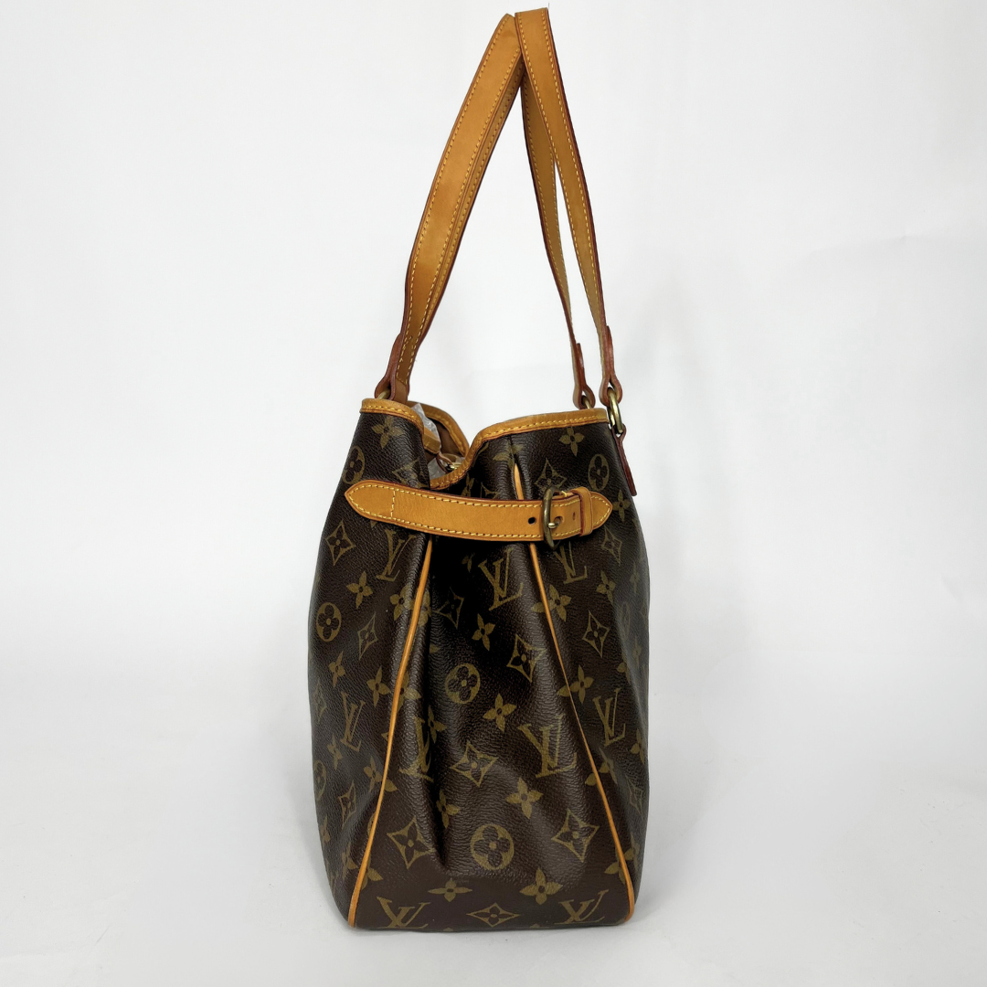 Brown monogram handbag with tan leather handle on a white background