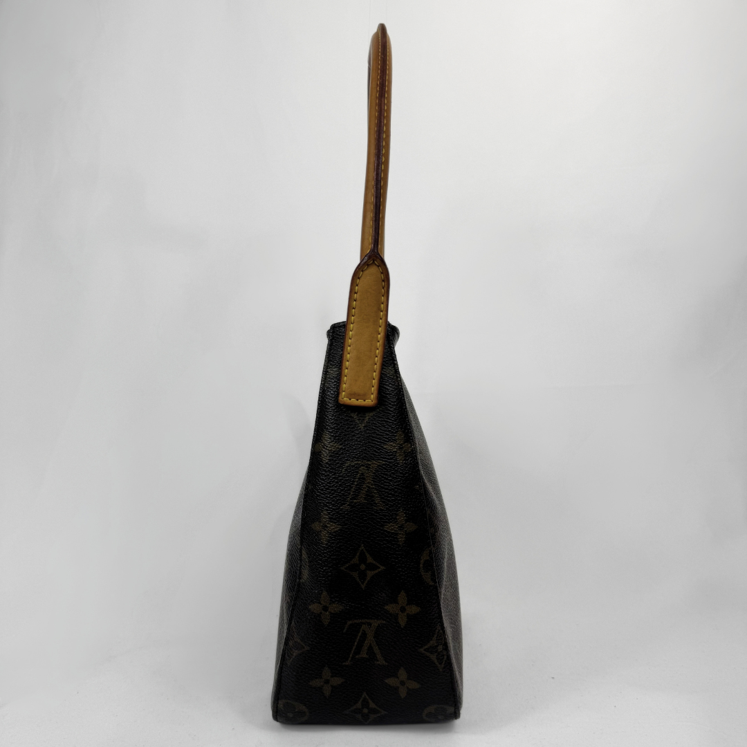 Louis Vuitton monogram canvas shoulder bag in black with tan leather trim and handle, shown from the side against a light gray background.