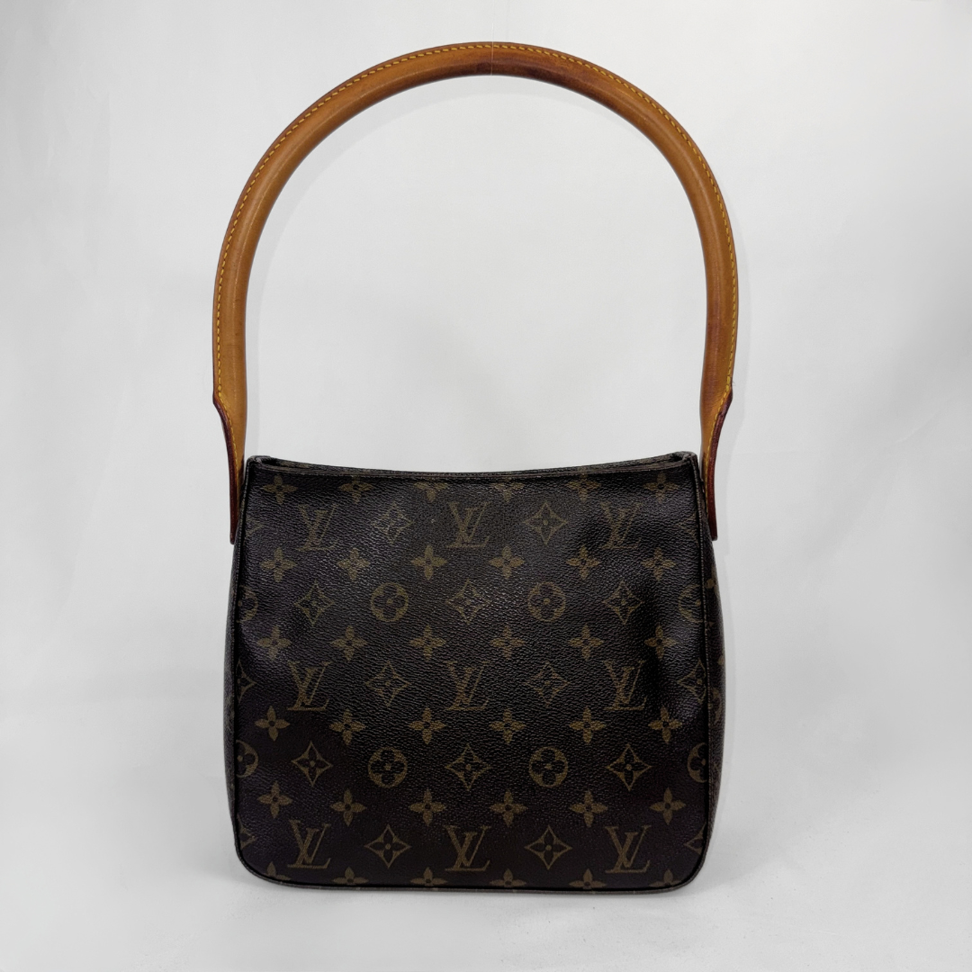 A Louis Vuitton monogram shoulder bag in dark brown coated canvas with a tan leather handle, photographed against a light gray background.