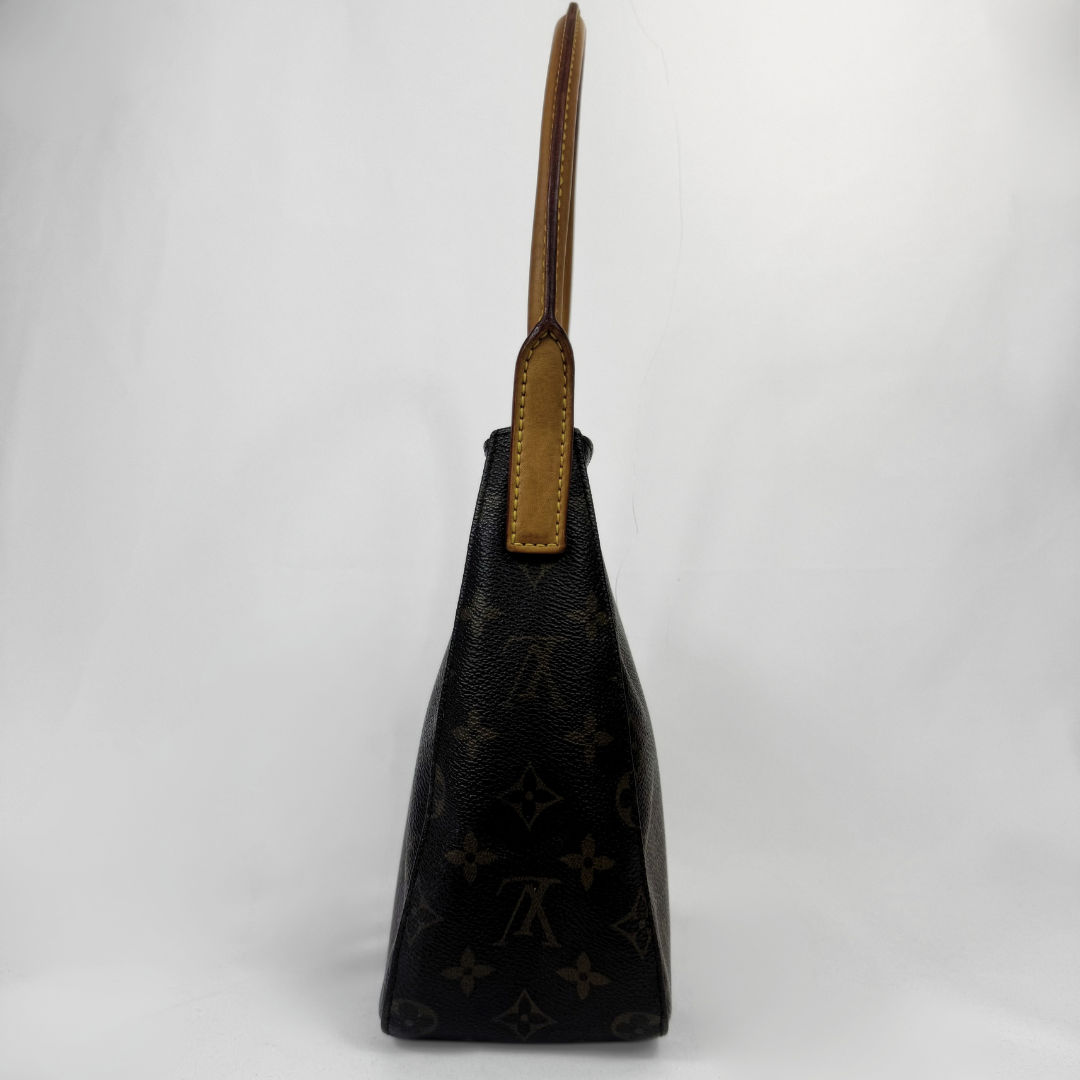 Louis Vuitton black monogram canvas shoulder bag with tan leather trim and handle, shown from the side against a white studio background.