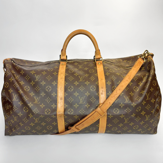Brown travel bag with tan leather straps on a white background
