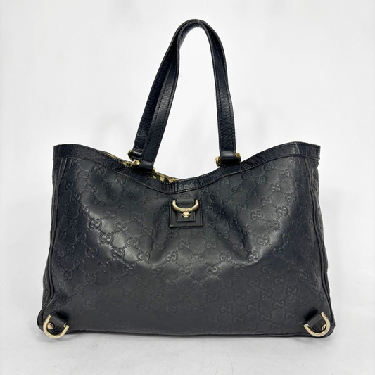 Black leather handbag with gold hardware on a white background