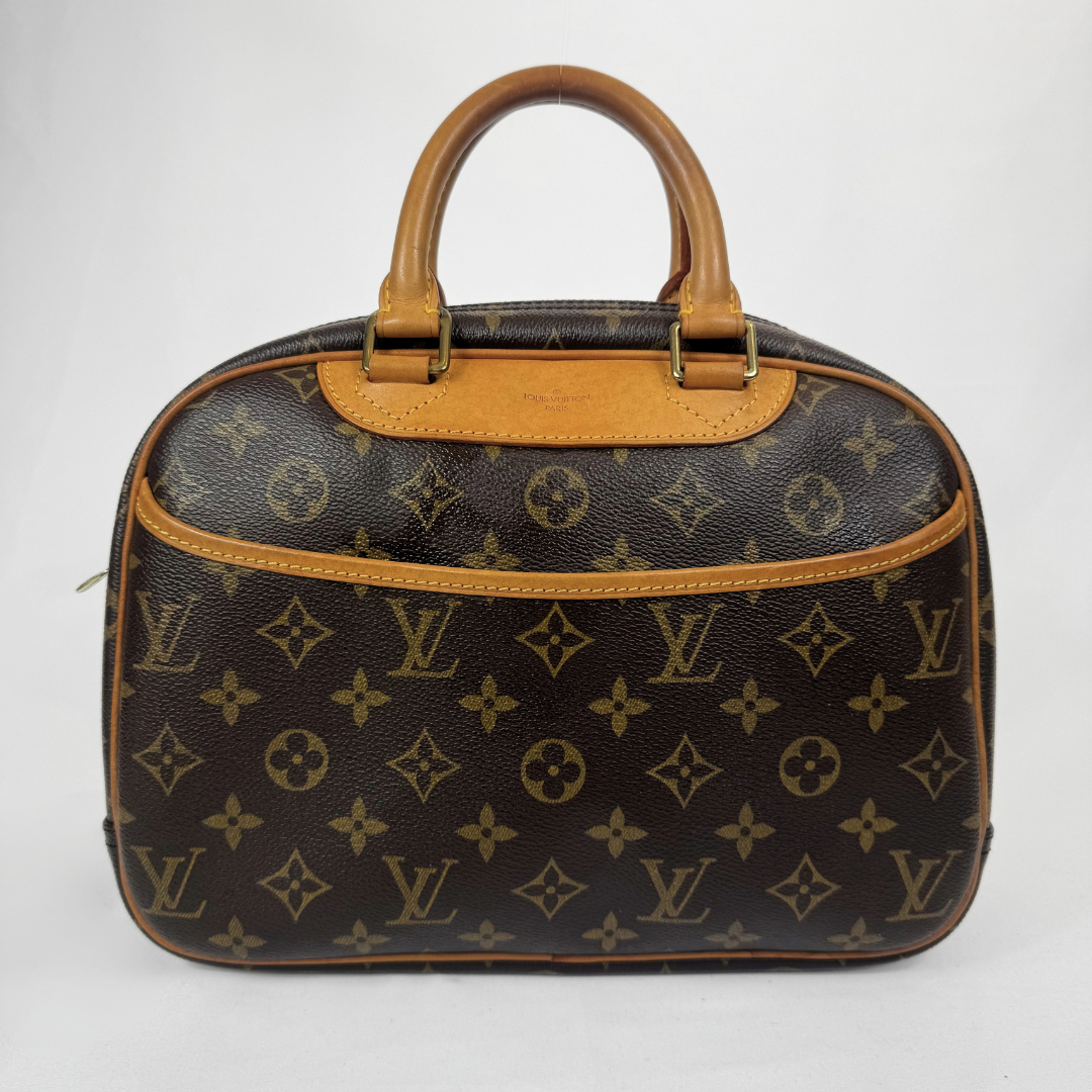 Louis Vuitton monogram canvas top-handle satchel in dark brown with tan leather trim and handles, shown against a plain light gray background.