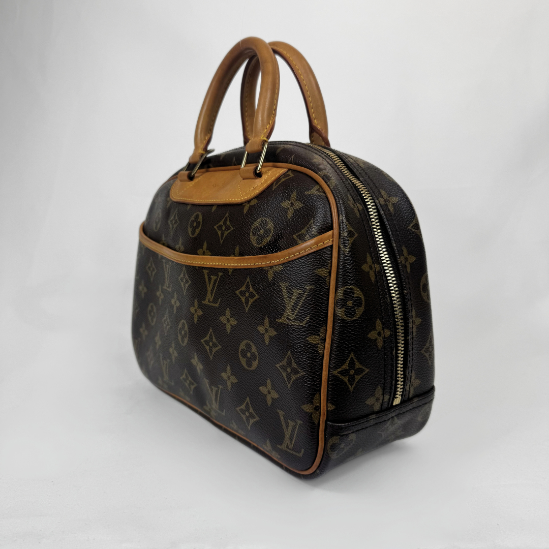Louis Vuitton monogram canvas handbag with tan leather handles and trim, shown on a light gray background.