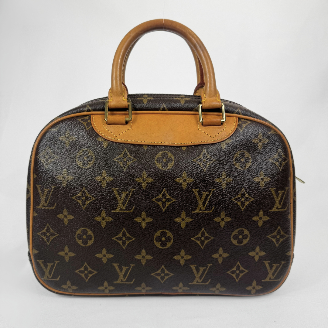 Louis Vuitton monogram canvas handbag with tan leather handles and trim, shown against a plain light gray background.