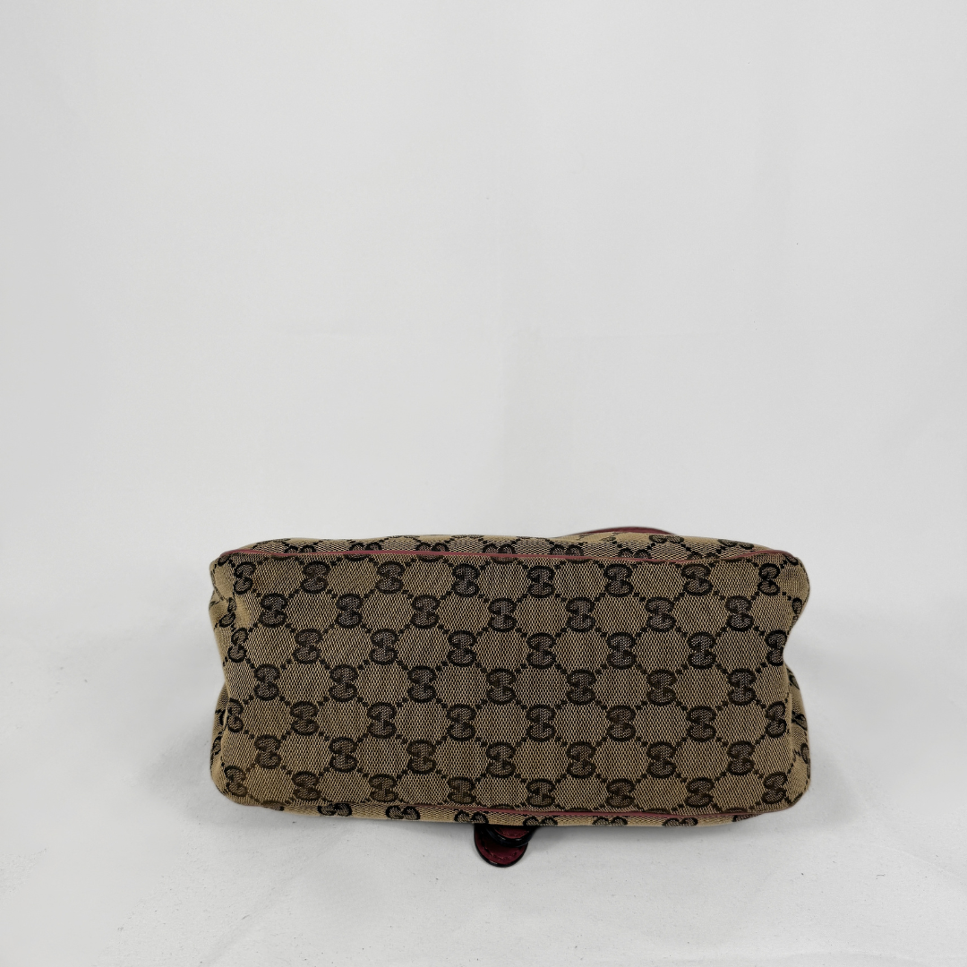 A vintage-style canvas pouch featuring the classic brown and beige GG monogram pattern, photographed against a plain white background.
