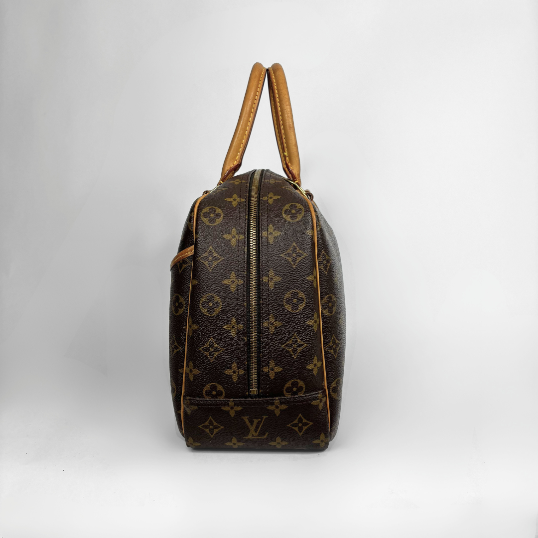 Louis Vuitton monogram canvas shoulder bag with tan leather handles, shown from the back on a light gray background.