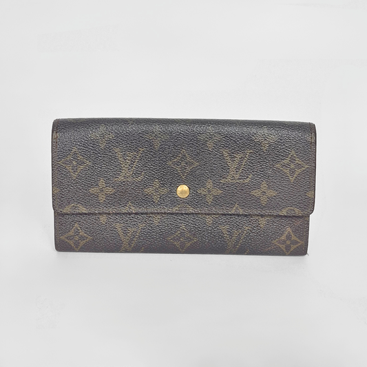 Louis Vuitton wallet with monogram pattern on a light gray background