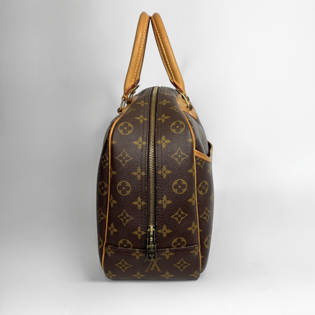 Louis Vuitton monogram canvas duffel bag with tan leather handles and trim, shown from the side against a light gray background.