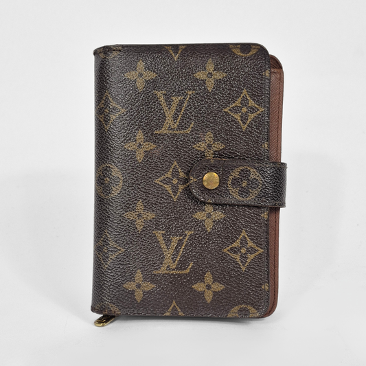 Louis Vuitton monogram patterned wallet on a light gray background