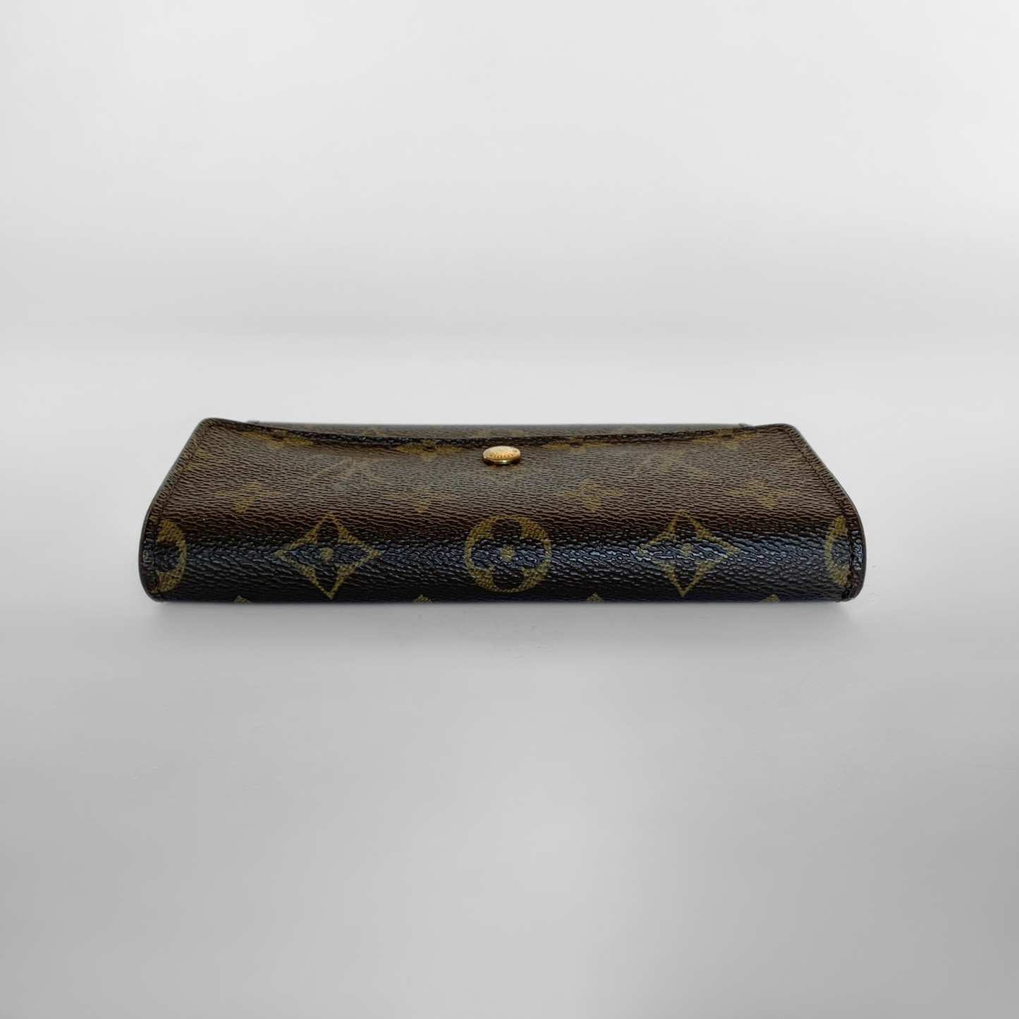 Brown leather wallet with gold accents on a light gray background