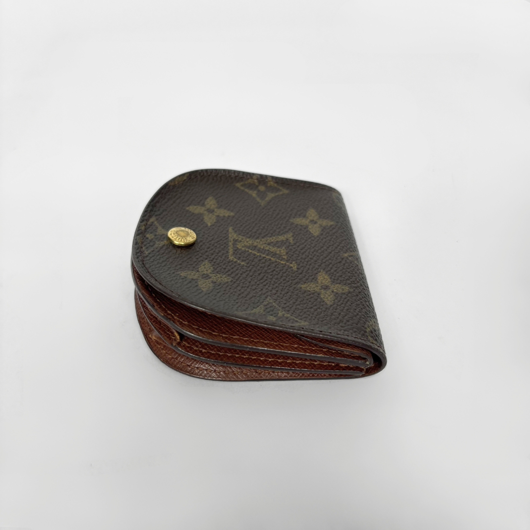 Louis Vuitton wallet with monogram pattern on a white background