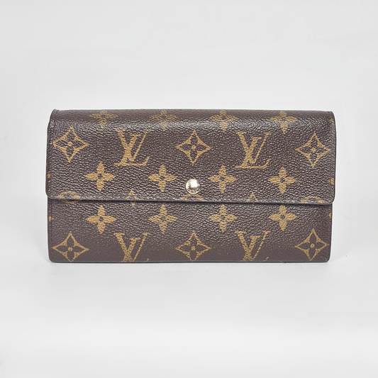 Designer wallet with monogram pattern on a light gray background
