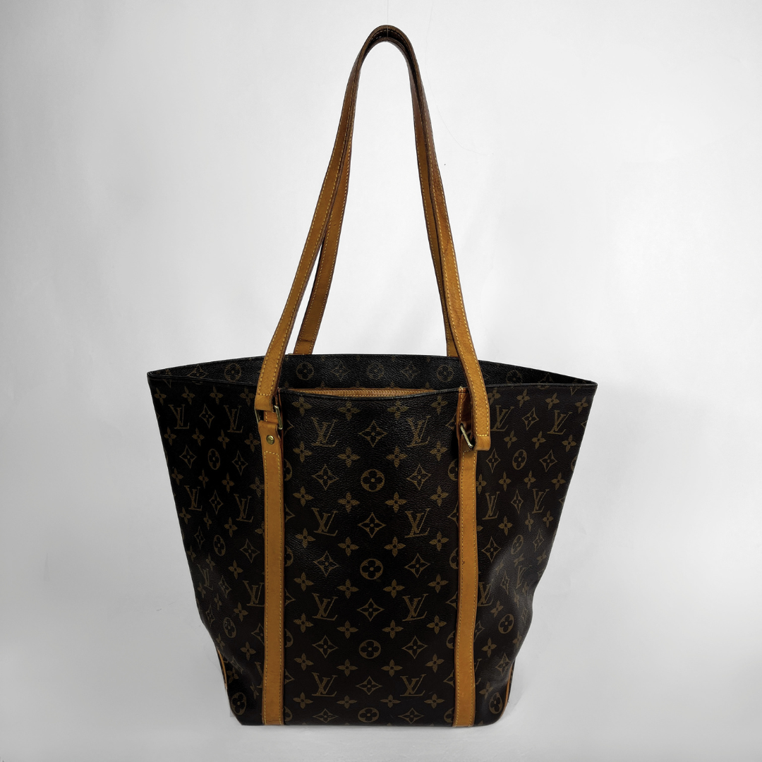 Louis Vuitton monogram canvas tote bag with tan leather shoulder straps and trim, shown against a plain light gray background.