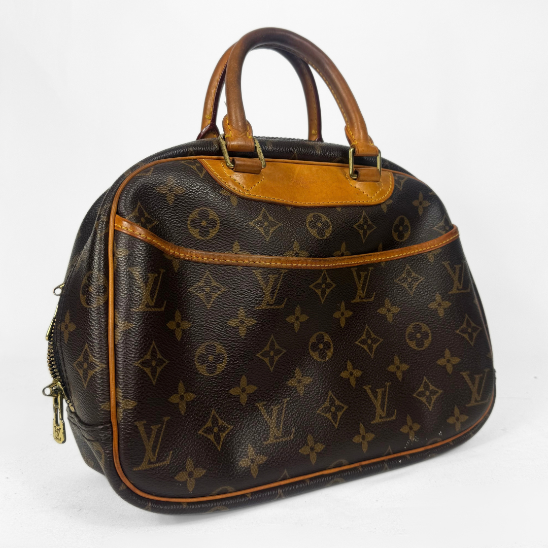 A Louis Vuitton monogram canvas dome handbag with brown leather handles and trim, shown on a plain white background.