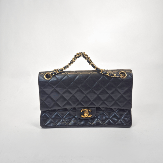 Black Chanel handbag with gold chain handle and clasp on a white background