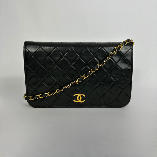 Black Chanel bag on white background