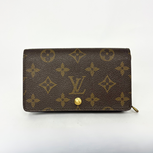 Louis Vuitton wallet with monogram pattern on a white background