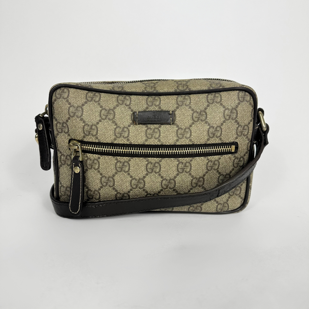 Gucci handbag with monogram pattern on a light gray background