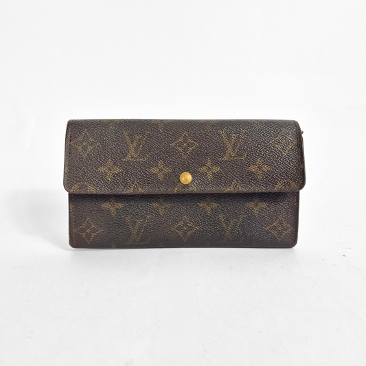 Brown wallet with gold monogram pattern on a white background