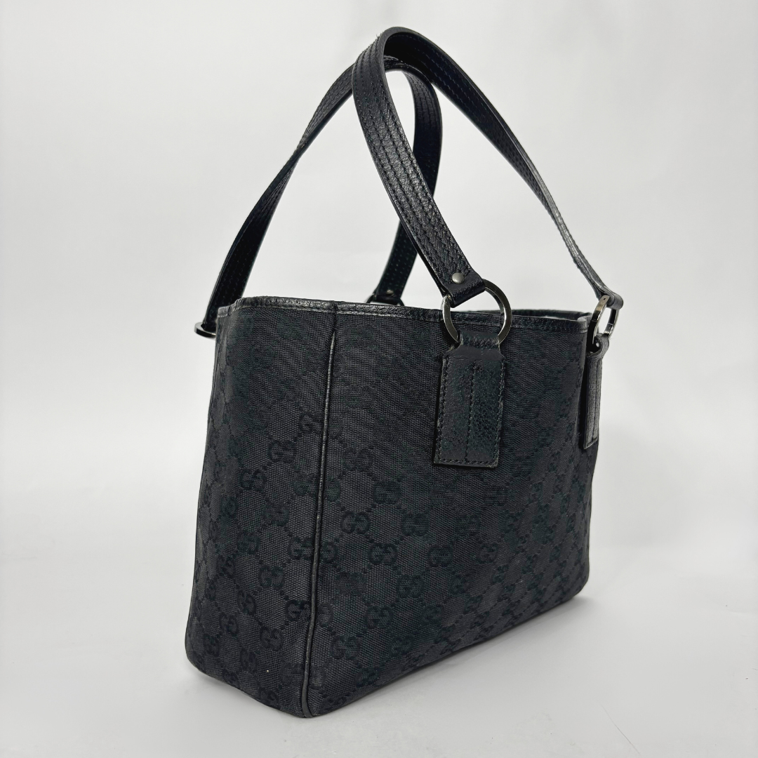 Black textured handbag on a light gray background