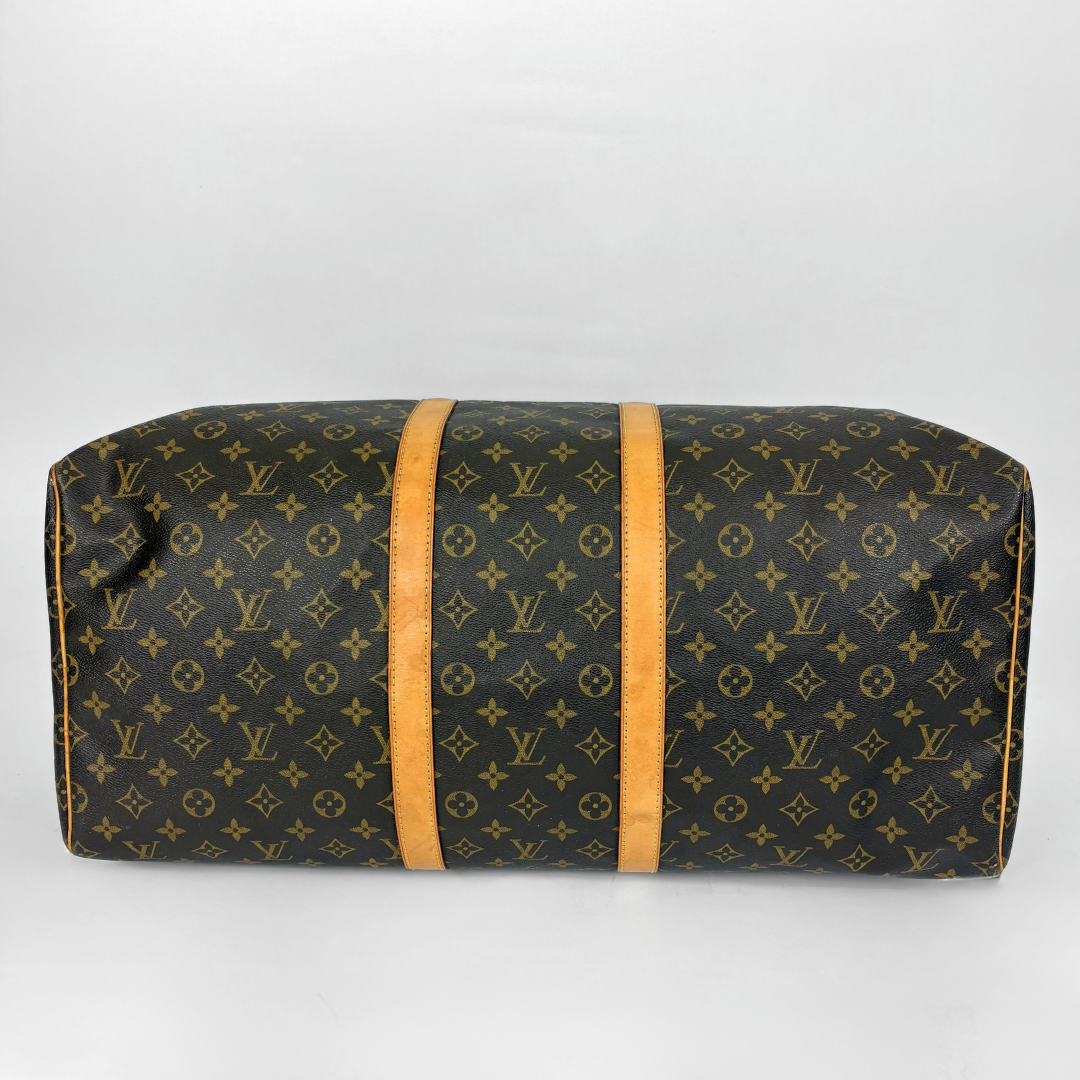 Louis Vuitton monogram duffel bag with tan straps on a light gray background