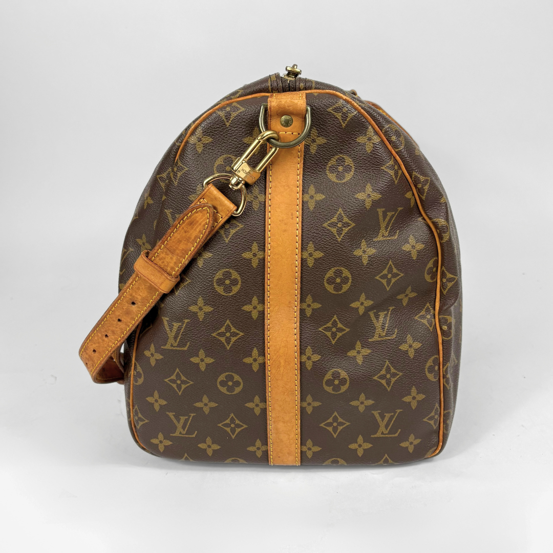 Brown duffel bag with tan leather straps and handle on a white background